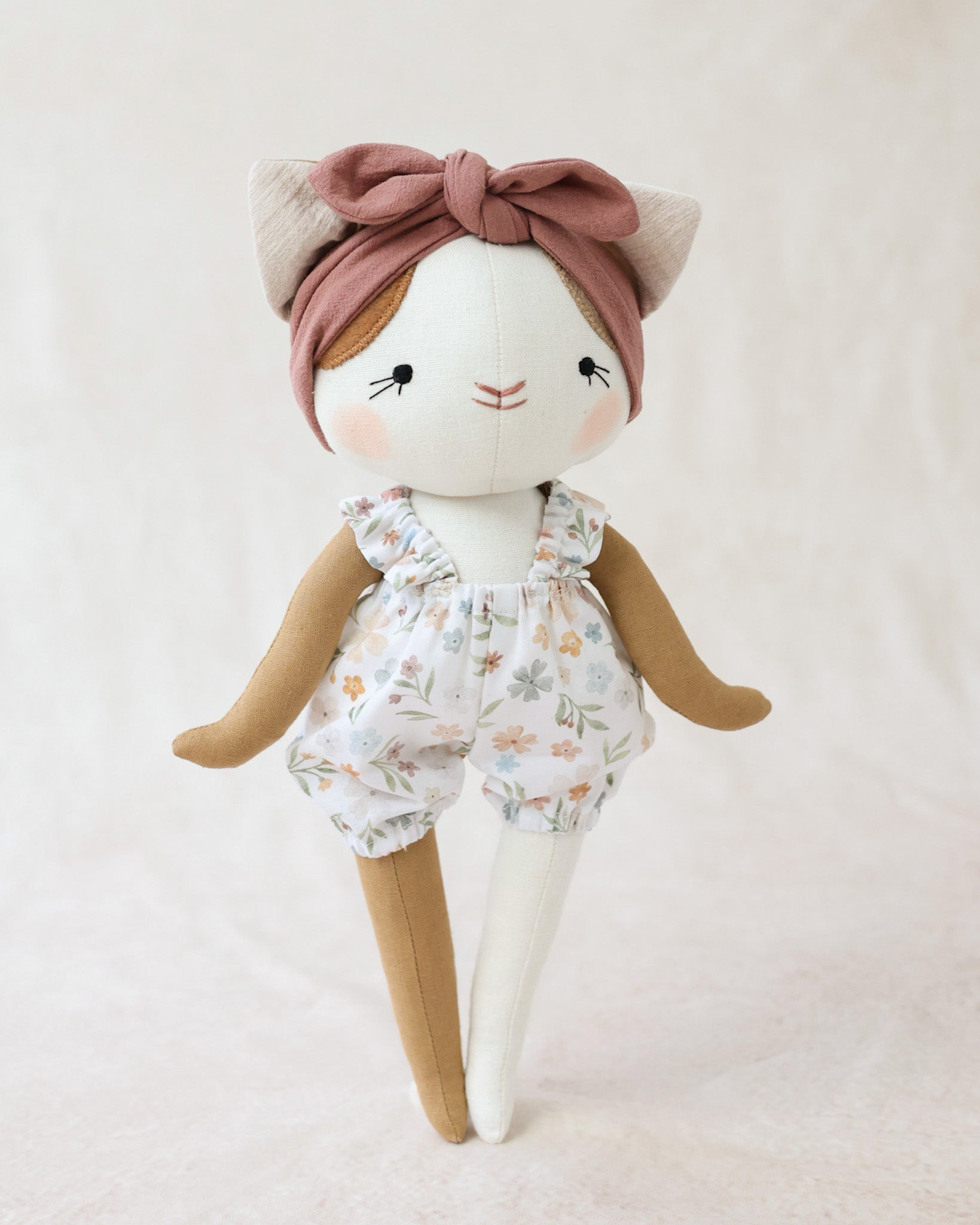 花柄のサスペンダーブルマを着た猫のぬいぐるみルーシー