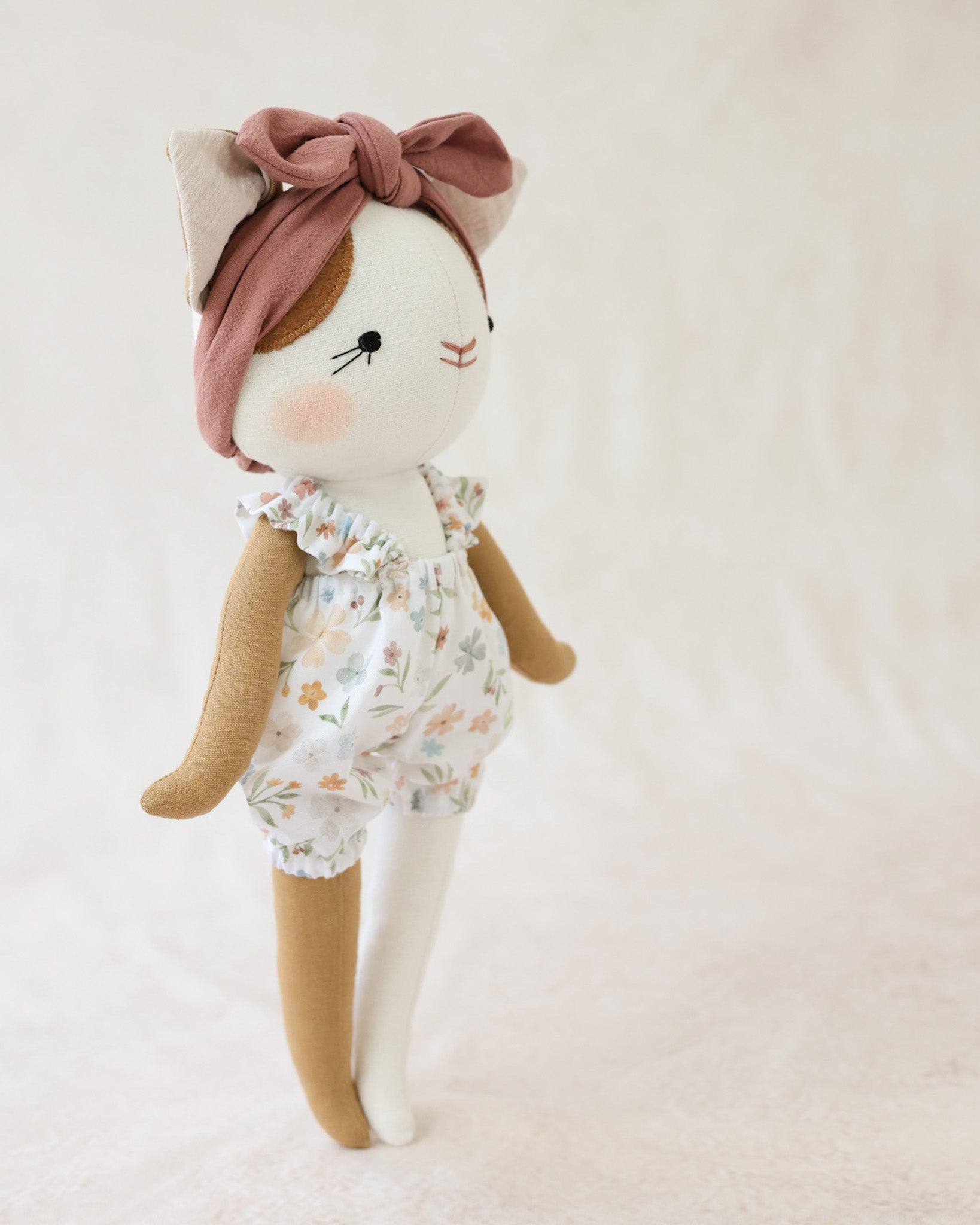 花柄のサスペンダーブルマを着た猫のぬいぐるみルーシー