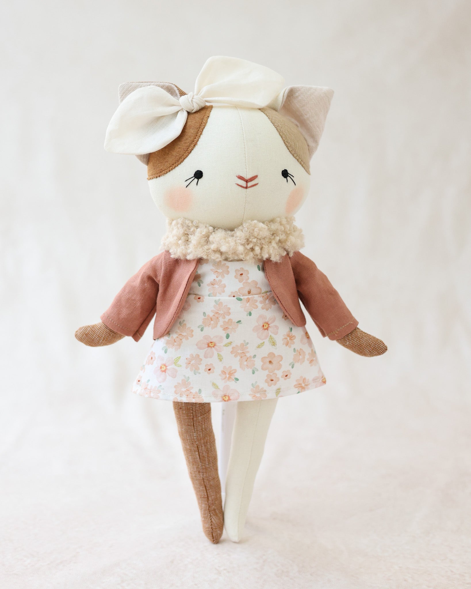 猫のぬいぐるみルーシー、ブラッシュフローラルドレスを着て